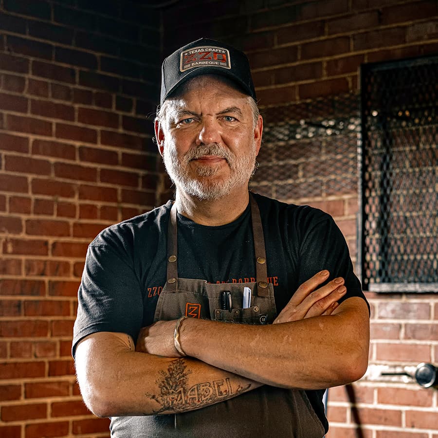 a guy crossed arms in an apron