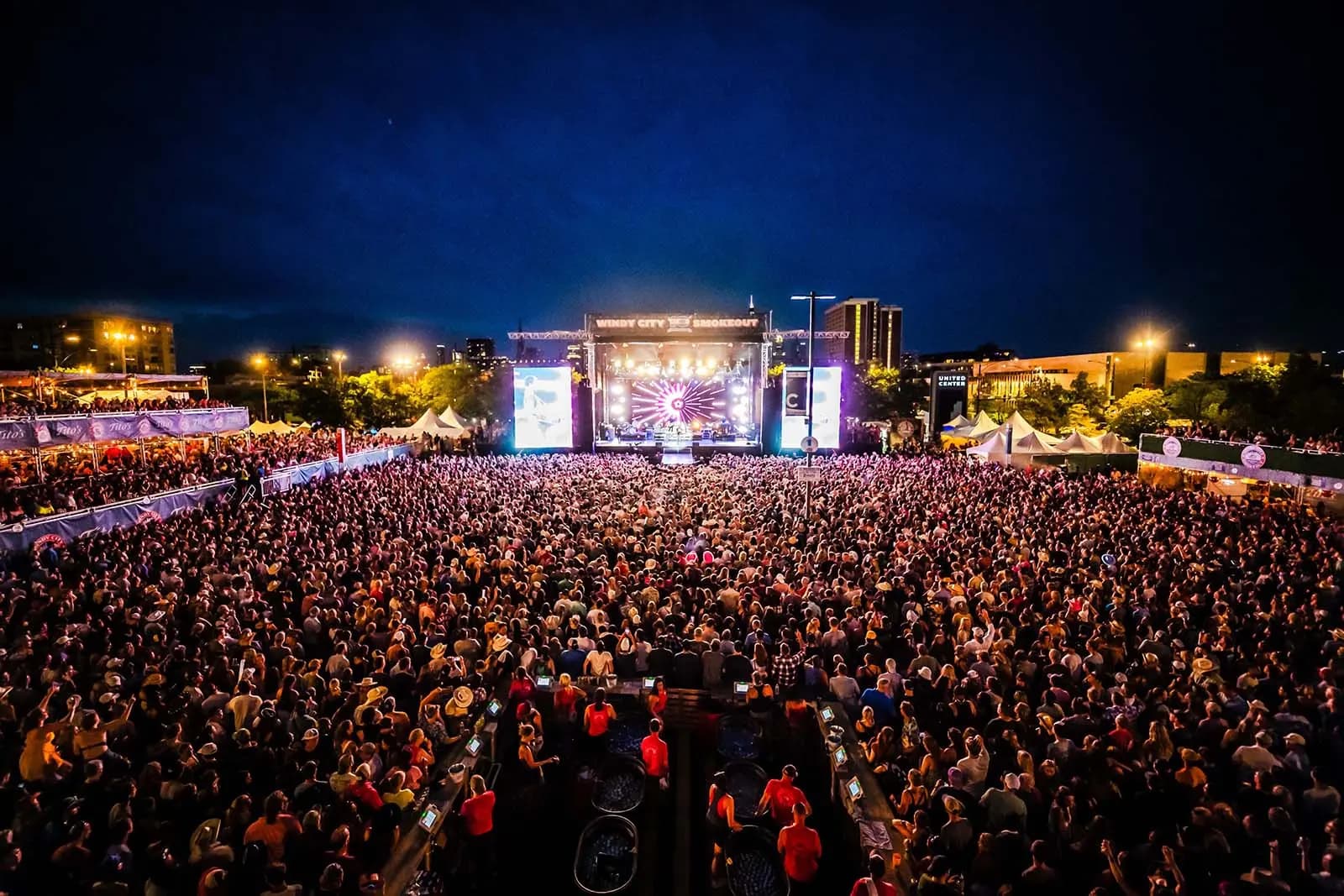 large crowd looking at a brightly lit main stage